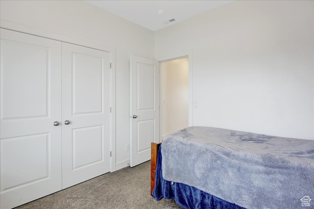 Bedroom featuring carpet flooring and a closet