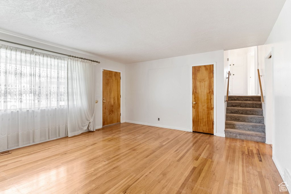 Spare room with light hardwood / wood-style floors and a textured ceiling