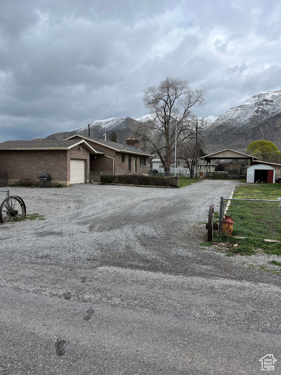 View of front of property with a front yard, a mountain view, and a garage