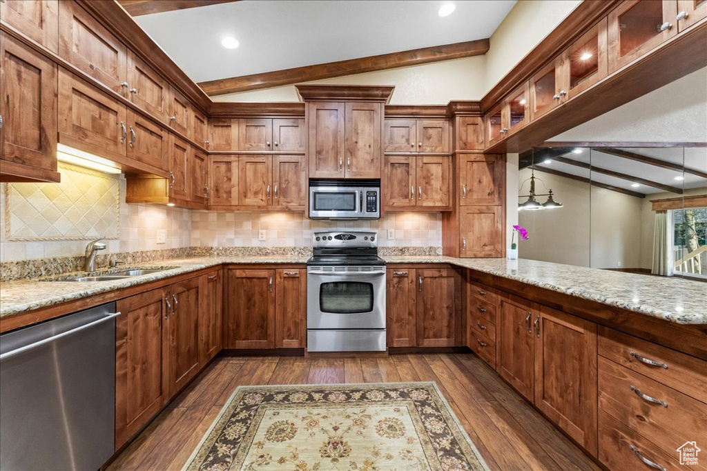 Kitchen with appliances with stainless steel finishes, backsplash, dark hardwood / wood-style flooring, and lofted ceiling with beams