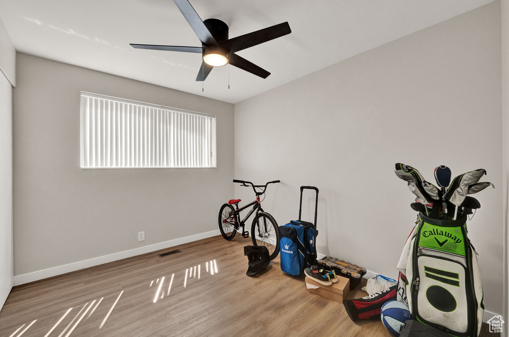 Workout area featuring light hardwood / wood-style floors and ceiling fan