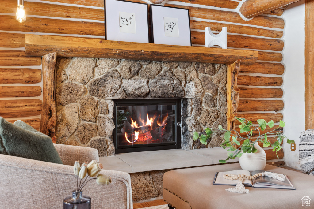 Room details with a stone fireplace and log walls