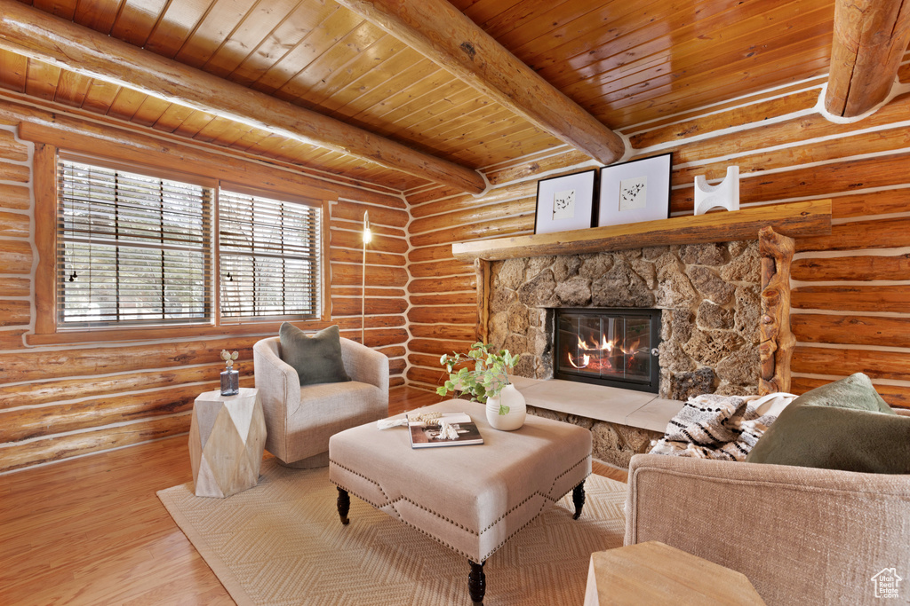 Living room featuring a fireplace, rustic walls, wooden ceiling, beamed ceiling, and light wood-type flooring