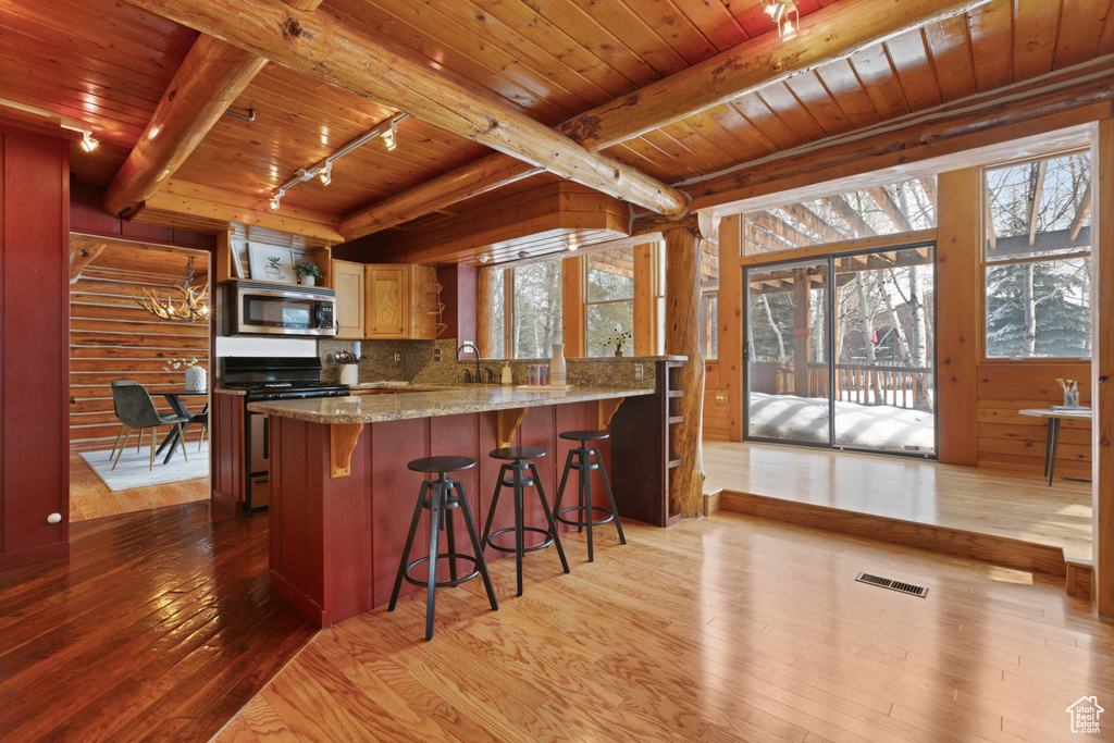 Kitchen featuring wooden ceiling, tasteful backsplash, light hardwood / wood-style flooring, range, and track lighting