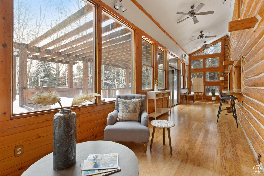 Living area featuring vaulted ceiling, ceiling fan, a wealth of natural light, and light wood-type flooring