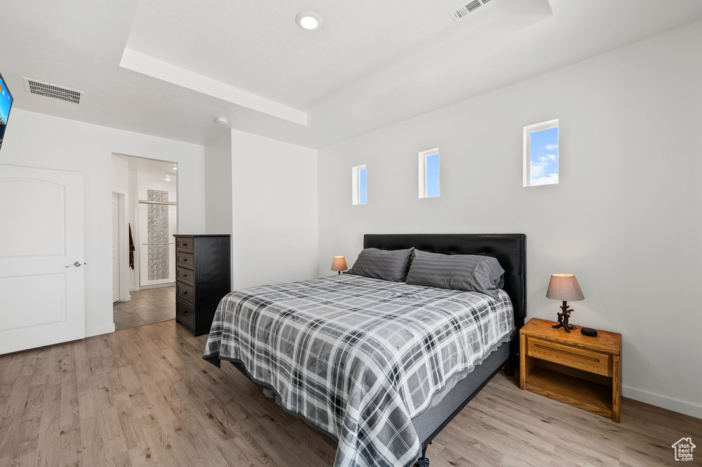 Bedroom featuring a tray ceiling and light wood-type flooring