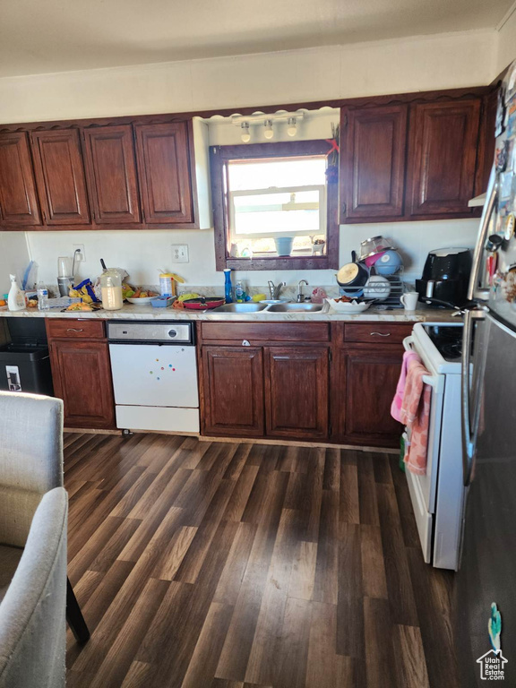 Kitchen featuring white appliances, sink, and dark hardwood / wood-style flooring