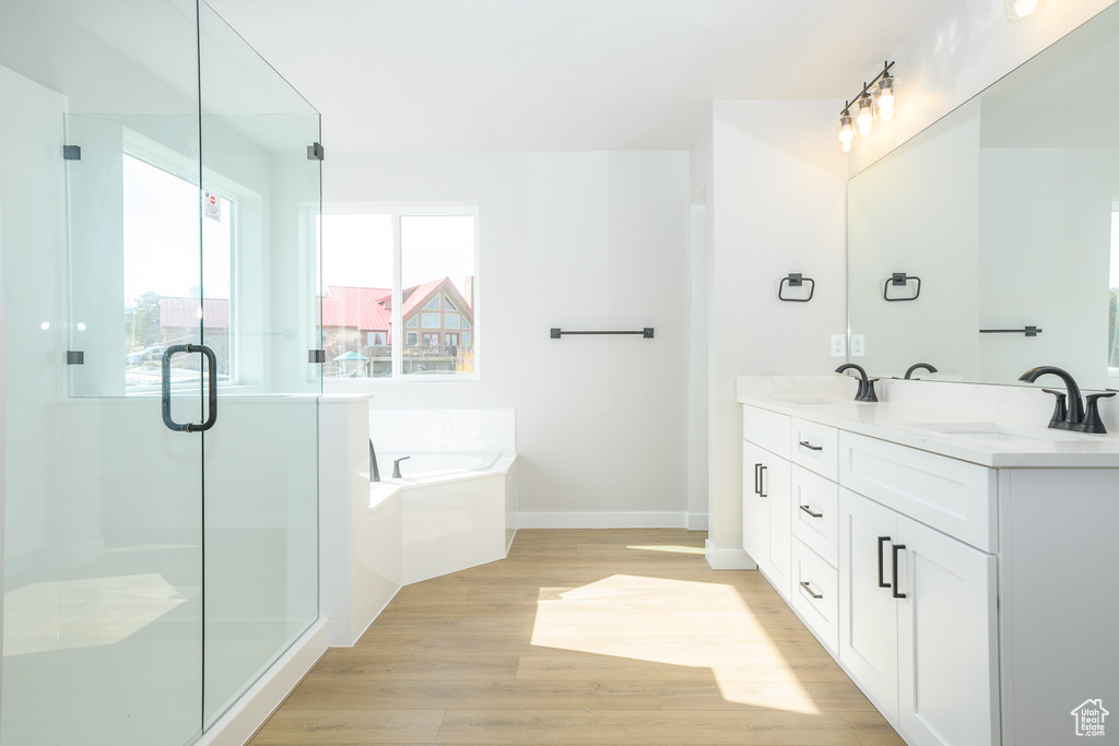 Bathroom with dual bowl vanity, plus walk in shower, and hardwood / wood-style flooring