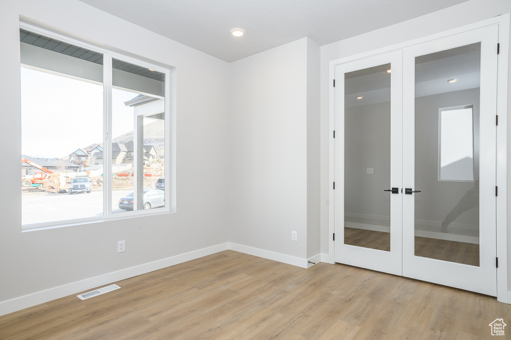 Unfurnished room with light hardwood / wood-style flooring and french doors