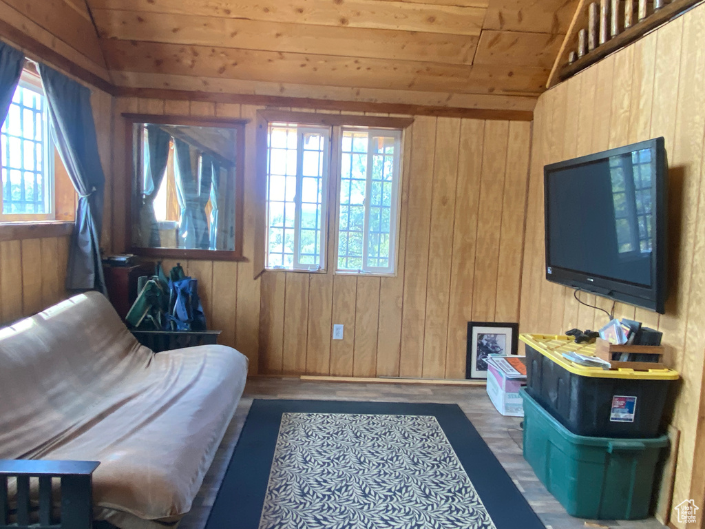 Sitting room featuring lofted ceiling and wooden walls