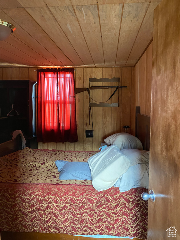 Unfurnished bedroom featuring wooden walls and wooden ceiling