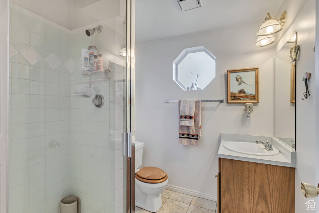 Bathroom featuring vanity, tile flooring, toilet, and walk in shower