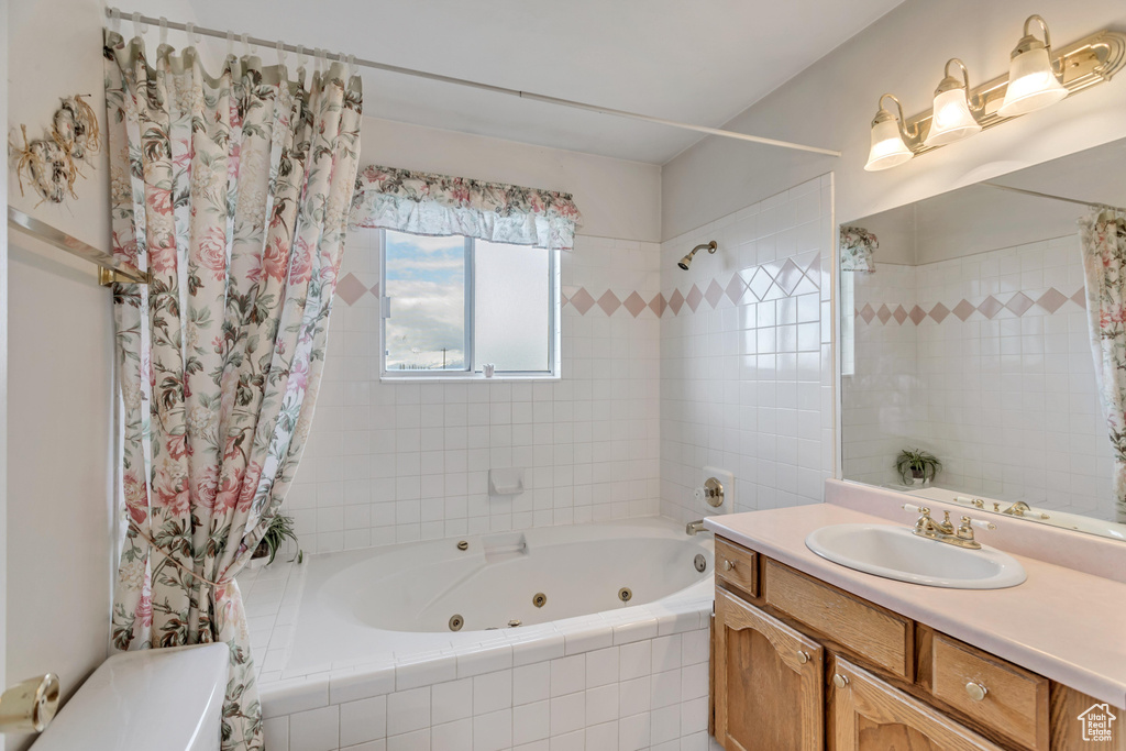 Full bathroom featuring oversized vanity, toilet, and shower / bathtub combination with curtain