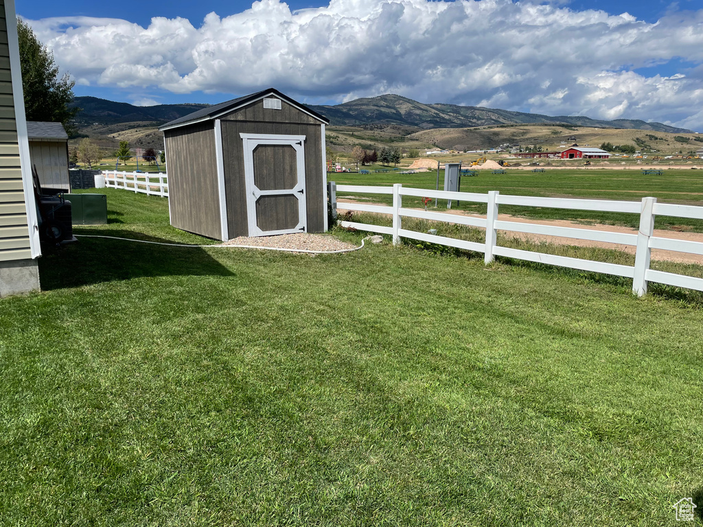 View of yard with a shed, a mountain view, and a rural view
