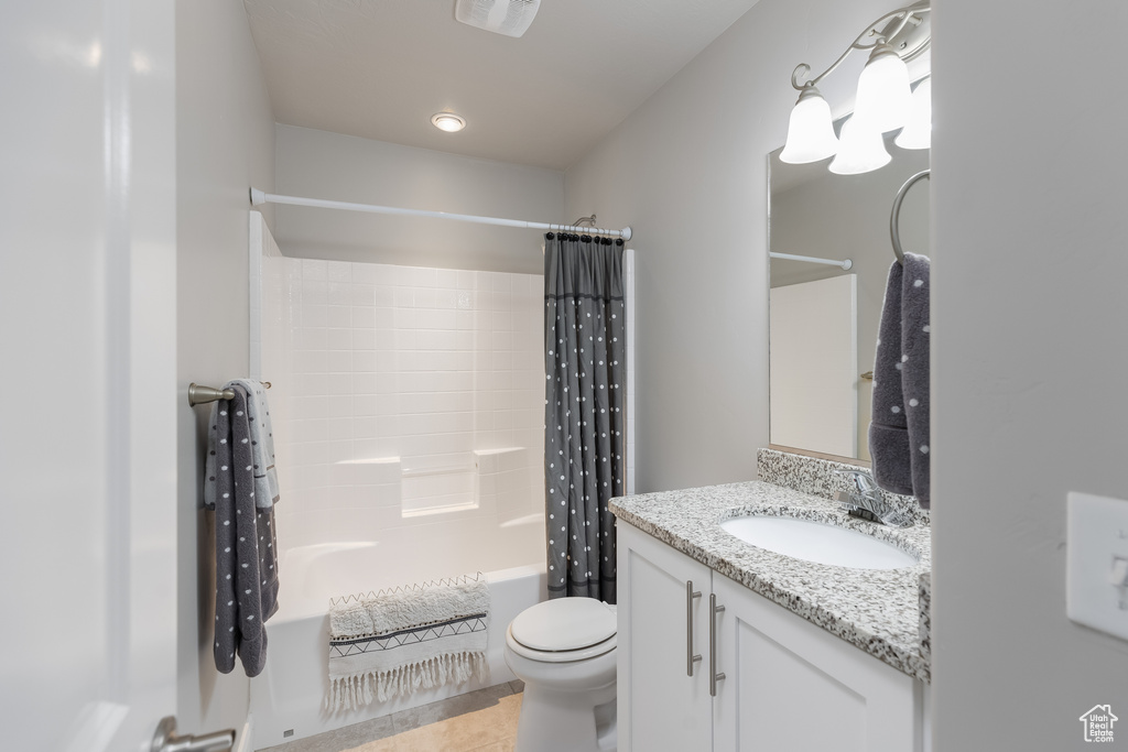 Full bathroom featuring tile floors, toilet, shower / bathtub combination with curtain, and vanity