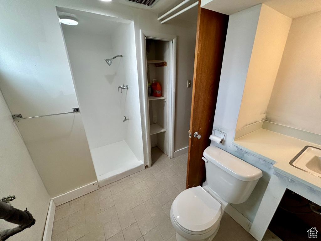 Bathroom with vanity, tile flooring, toilet, and walk in shower