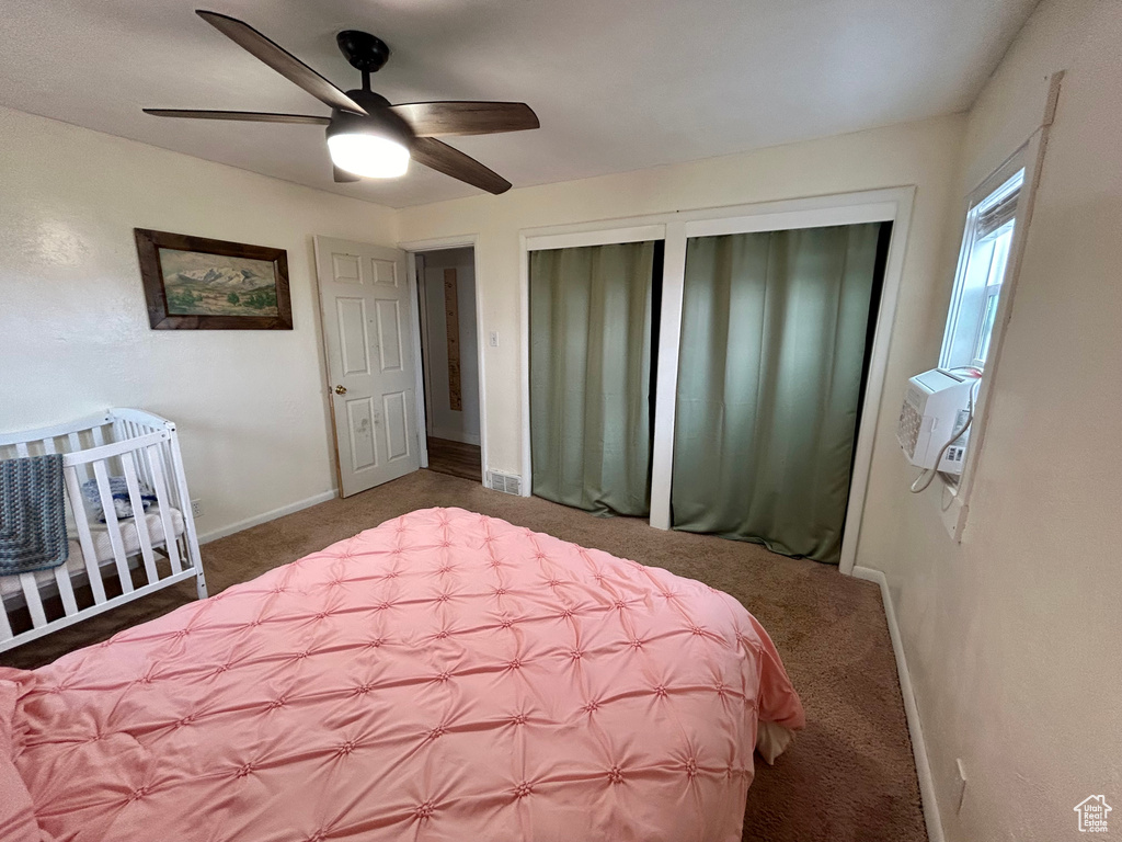 Carpeted bedroom with ceiling fan and multiple closets