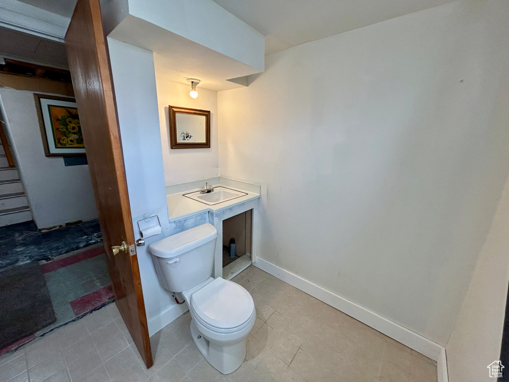 Bathroom with toilet, tile floors, and vanity
