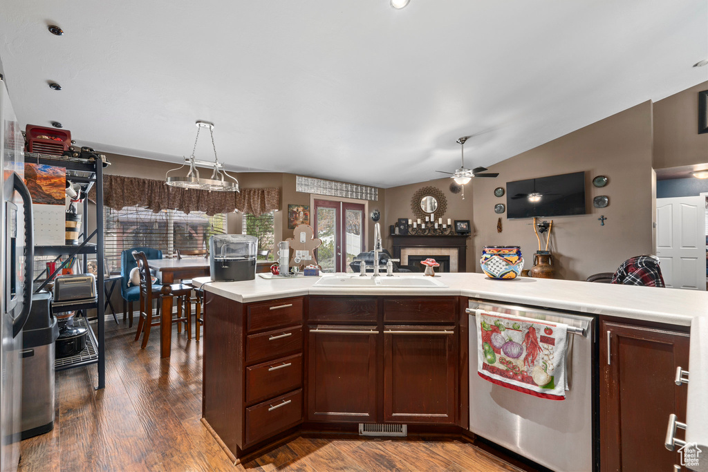 Kitchen featuring pendant lighting, ceiling fan, lofted ceiling, dishwasher, and dark hardwood / wood-style flooring