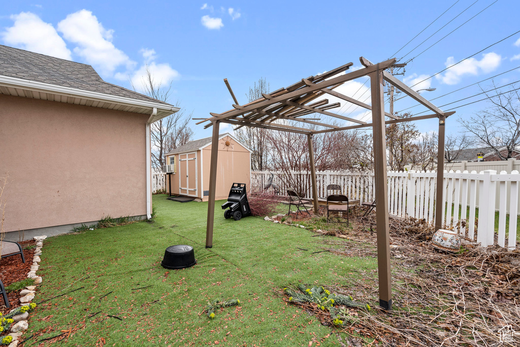 View of yard featuring a pergola and a storage shed