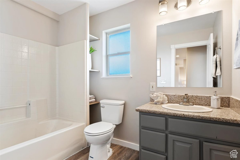 Full bathroom featuring shower / washtub combination, toilet, hardwood / wood-style floors, and vanity
