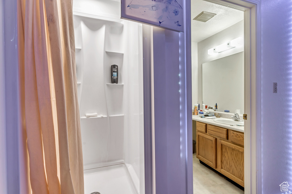 Bathroom featuring walk in shower and oversized vanity
