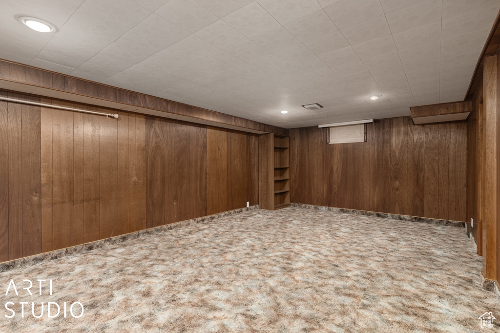 Basement with carpet flooring and wooden walls