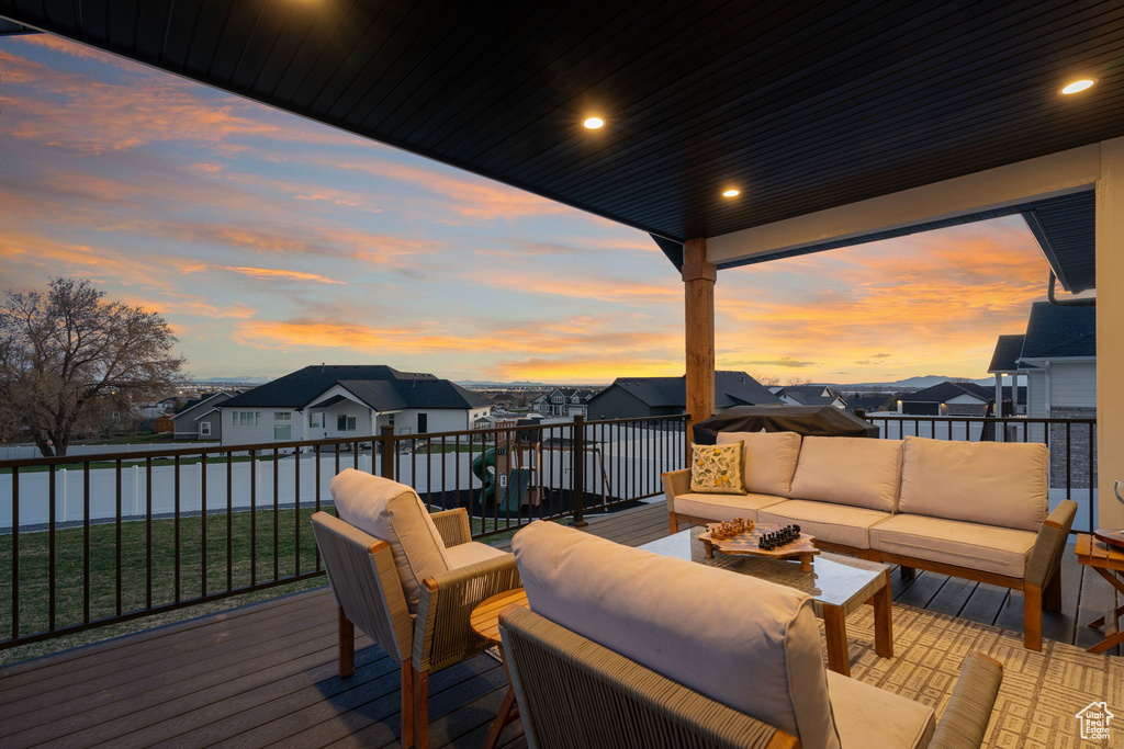 Deck at dusk featuring a yard and outdoor lounge area