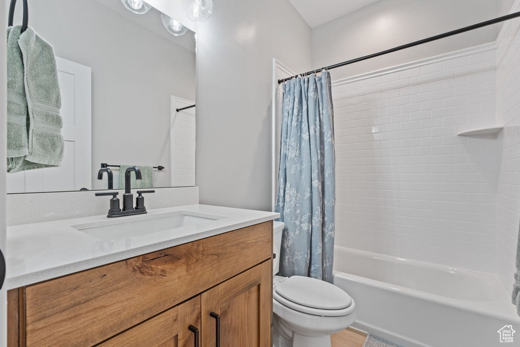 Full bathroom with shower / tub combo, oversized vanity, and toilet