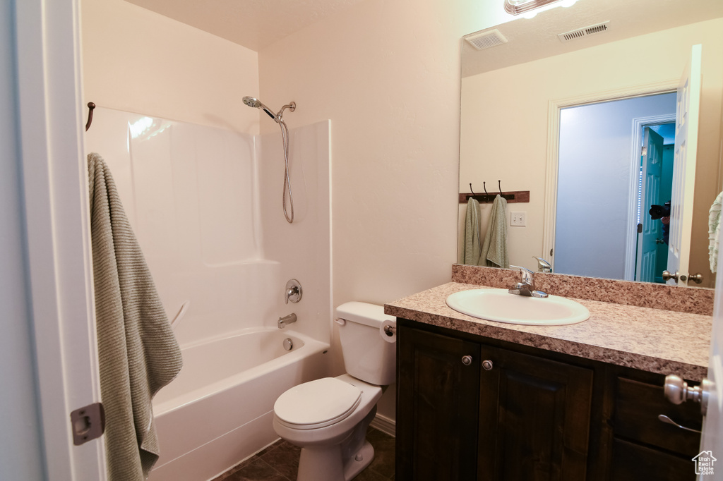 Full bathroom featuring toilet, vanity, shower / bath combination, and tile flooring
