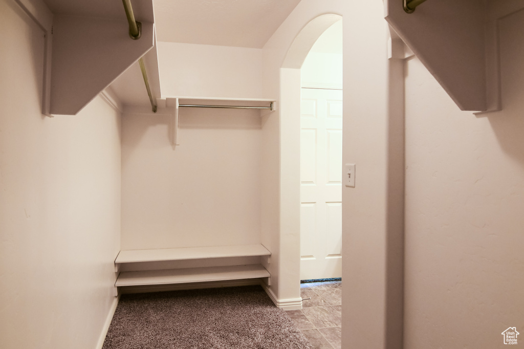 Spacious closet featuring light tile flooring