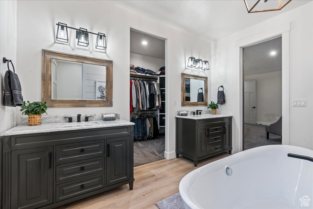 Bathroom featuring vanity, a bathtub, and wood-type flooring