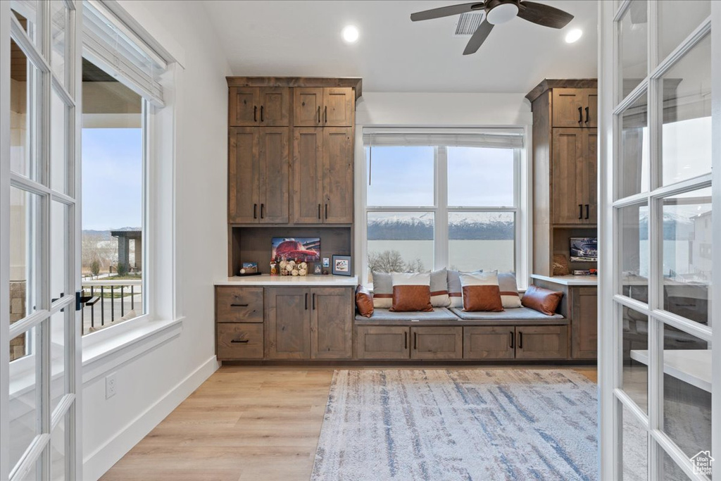 Interior space with a water view, light hardwood / wood-style floors, and ceiling fan