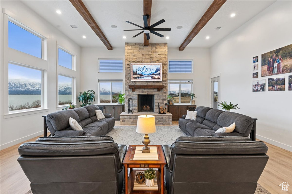 Living room featuring light hardwood / wood-style flooring, ceiling fan, a healthy amount of sunlight, and a fireplace