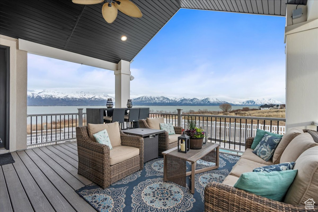 Deck featuring an outdoor living space, a water and mountain view, and ceiling fan