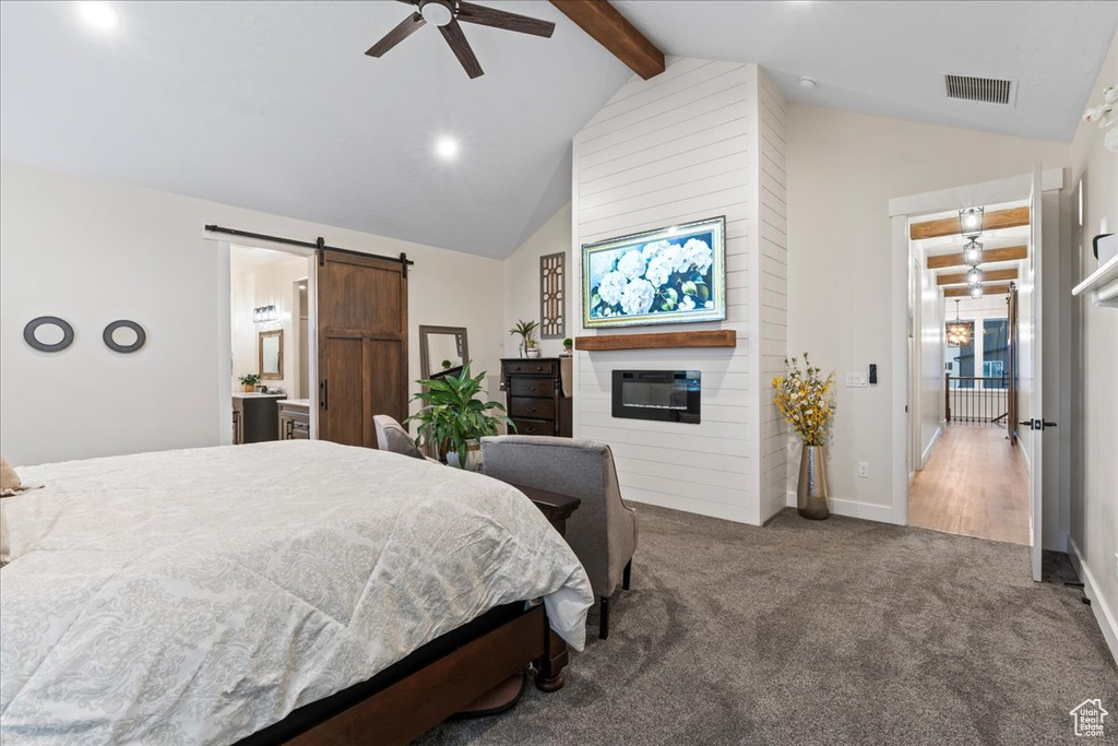 Carpeted bedroom with high vaulted ceiling, a fireplace, a barn door, ceiling fan, and beamed ceiling