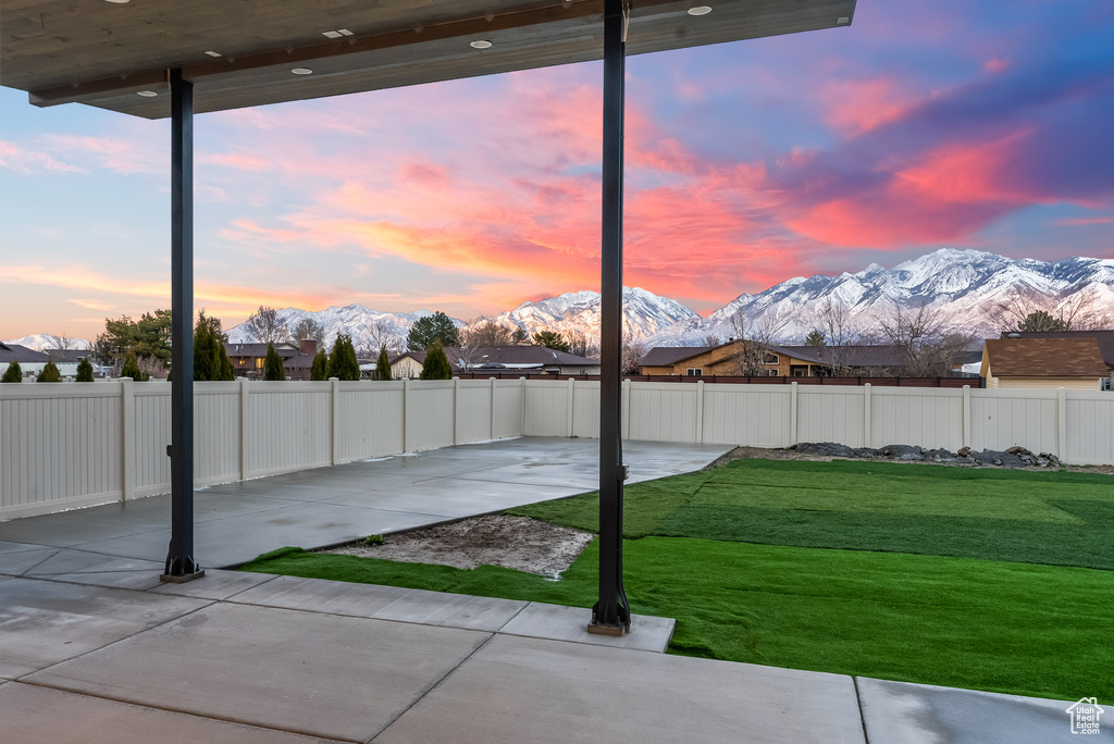 Yard at dusk with a patio area and a mountain view