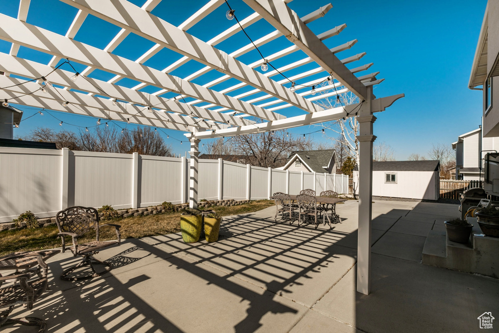 View of terrace featuring a storage unit and a pergola