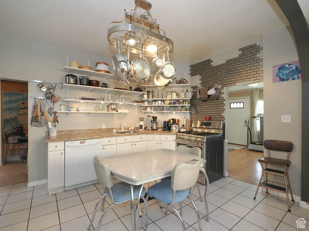 Dining space with light tile floors, brick wall, and sink