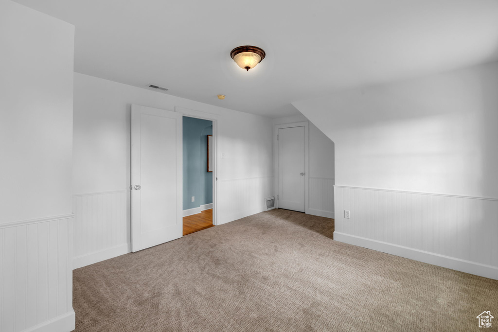 Bonus room featuring light carpet