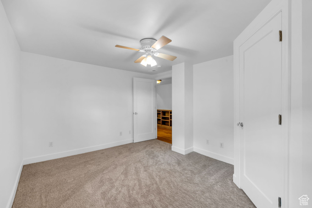 Unfurnished bedroom with light carpet and ceiling fan
