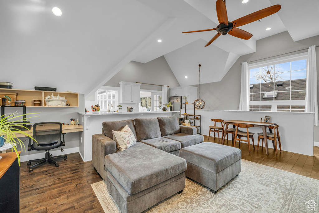 Living room featuring vaulted ceiling, wood-type flooring, ceiling fan, and a wealth of natural light
