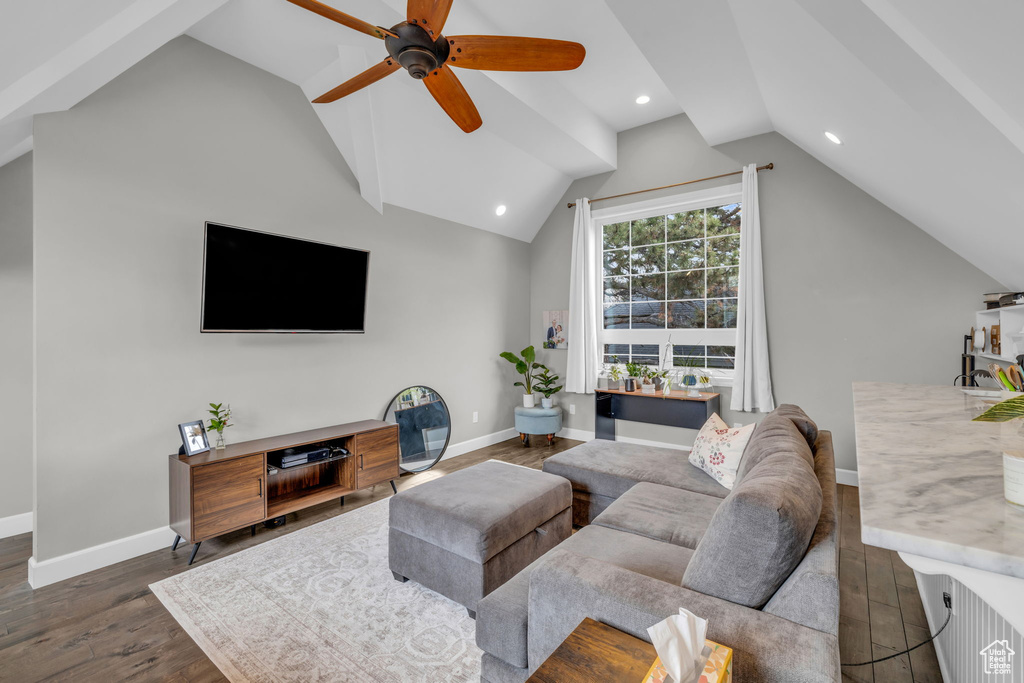 Living room featuring dark hardwood / wood-style flooring, ceiling fan, and lofted ceiling