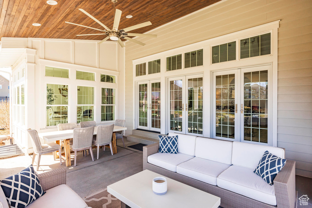 Sunroom / solarium featuring ceiling fan, wooden ceiling, and vaulted ceiling