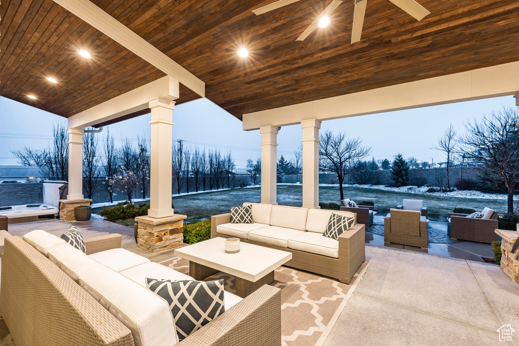 Patio terrace at dusk featuring an outdoor living space and ceiling fan