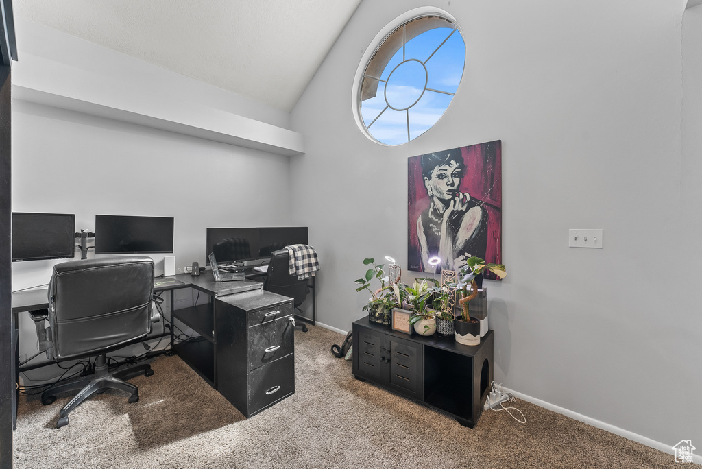 Office area with light colored carpet and vaulted ceiling