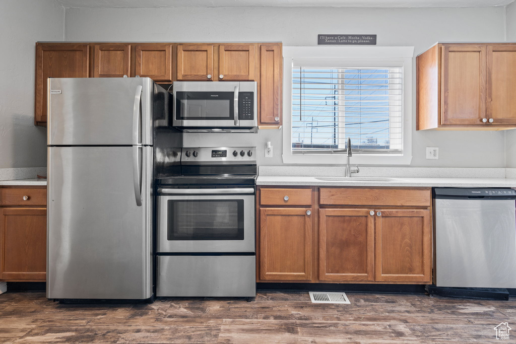 Kitchen featuring appliances with stainless steel finishes, dark hardwood / wood-style floors, and sink