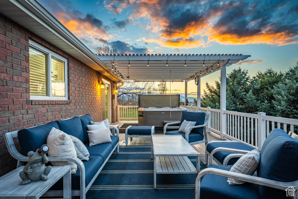 Patio terrace at dusk with an outdoor living space, a hot tub, and a pergola