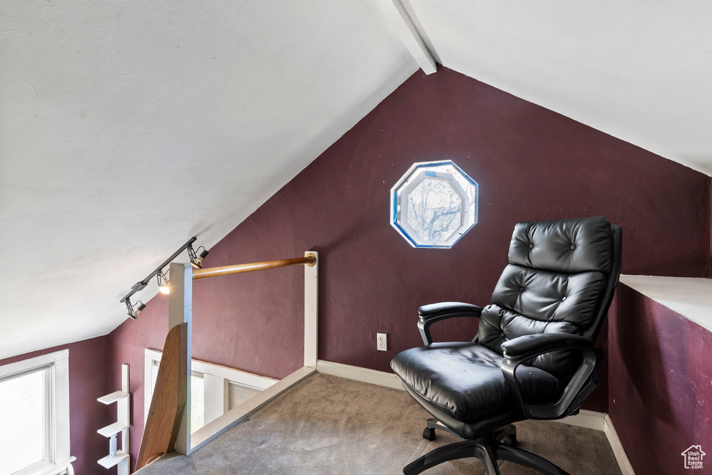 Carpeted home office with lofted ceiling with beams and track lighting