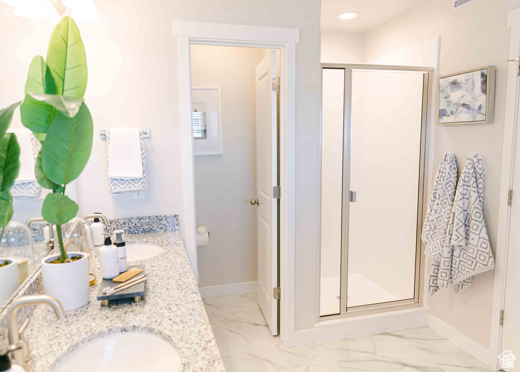 Bathroom featuring walk in shower, tile flooring, and dual bowl vanity